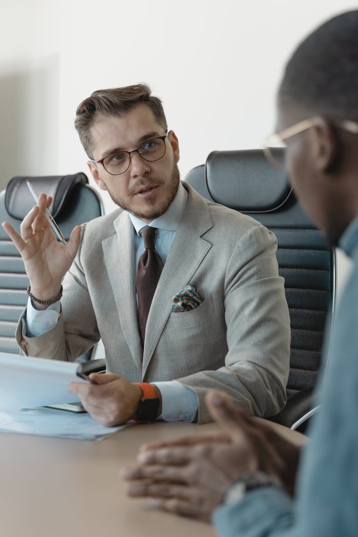 about-03 Two businessmen engaged in a professional meeting in a modern office setting.